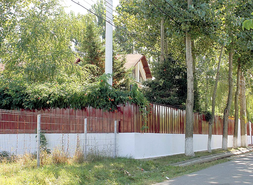 Vegetaţia abundentă şi  gardul înalt protejează vila  de ochii curioşilor