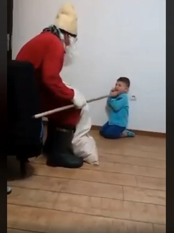 Băieţelul este ţinut în genunchi, la perete. Captura foto.