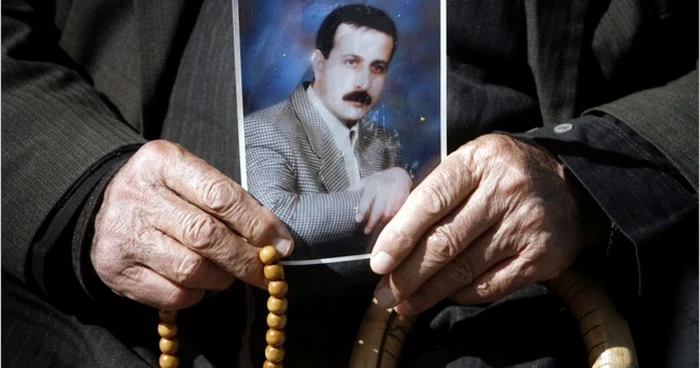 Tatăl oficialului din Hamas ţinând în mână o fotografie a liderului