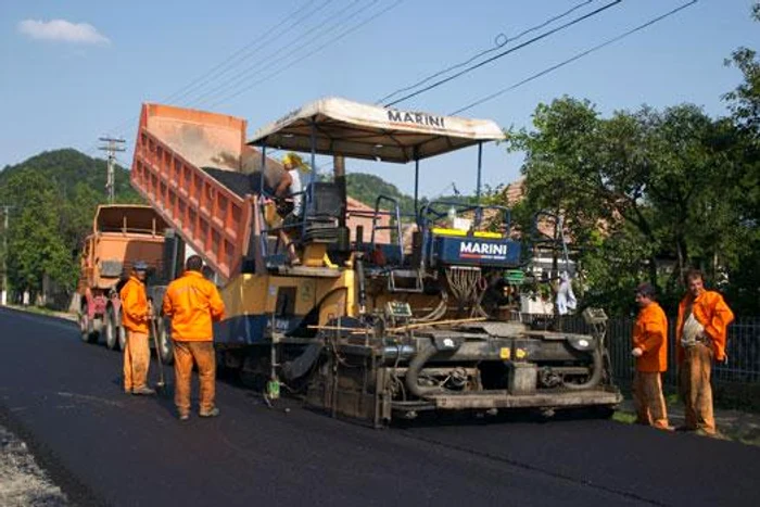 Muncitorii asfaltează, pun parapeți sau înlocuiesc glisiera de pe margine