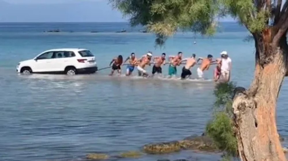 Momentul când un SUV este scos din mare de turiștii aflați pe o plajă din Grecia, viral pe internet VIDEO
