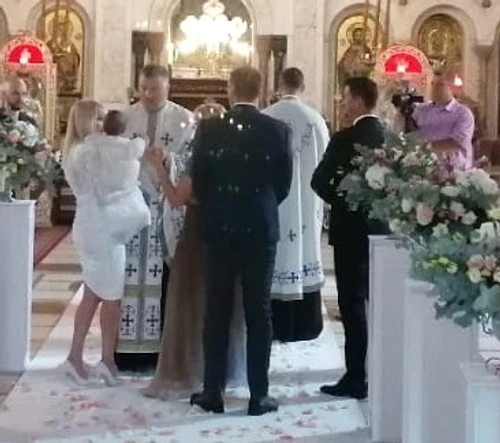 Elena Udrea își ține fetița în brațe în fața altarului