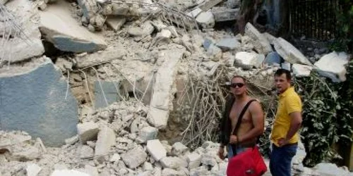 Emanuel Petruţ (în tricou galben) în faţa locuinţei prăbuşite