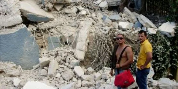 Emanuel Petruţ (în tricou galben) în faţa locuinţei prăbuşite