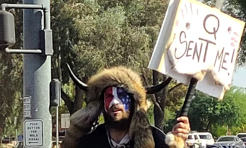 Jake Angeli (Qanon Shaman), seen holding a Qanon sign (cropped) jpg