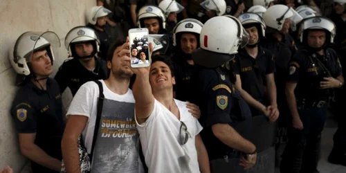 Demonstranţi pro-europeni îşi fac selfiuri cu poliţişti în faţa Parlamentului elen în timpul unui miting la Atena Grecia FOTO AP