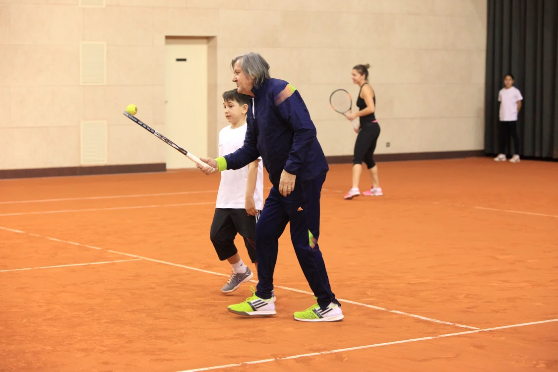 "Nasty" învaţă un copil cum să lovească mingea, iar Halep se încălzeşte pe fundal