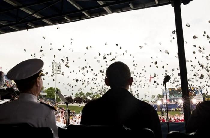 Barack Obama privea, pe 24 mai, caschetele aruncate în aer, de absolvenţii Academiei Navale din Annapolis, marinari şi infanterişti marini. Foto: Pete Souza.