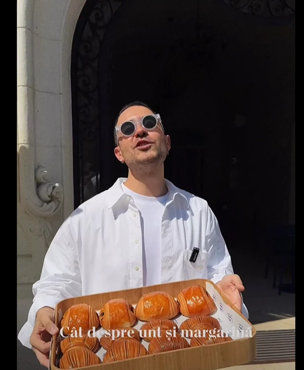 Edmond Niculușcă ține în brațe o cutie plină cu croissante