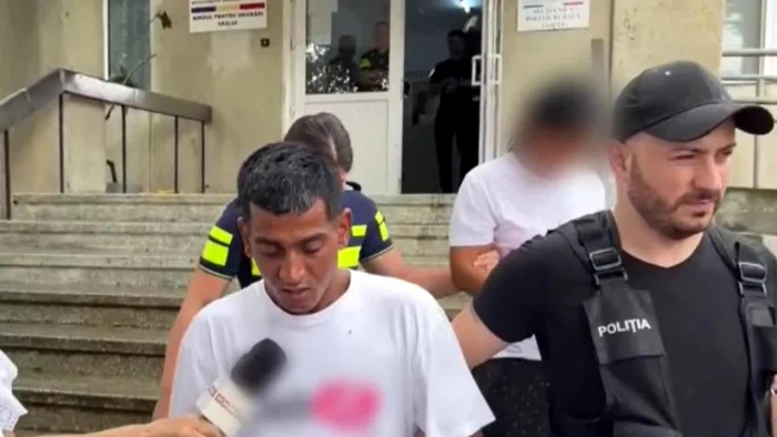Autorul crimei însoțit de un polițist.