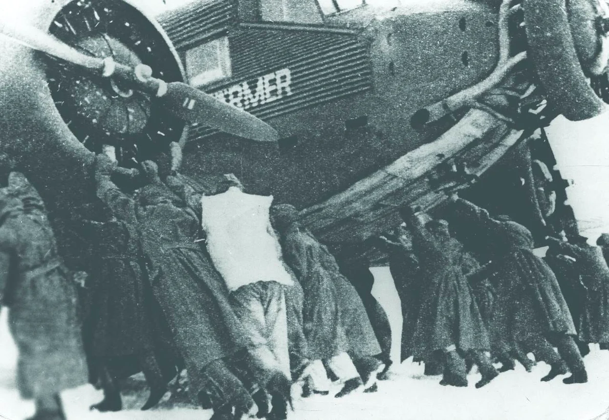 Prin zăpadă căzută pe aerodromul Pitomnik, soldați germani împing un avion Junkers-52, în timpul bătăliei de la Stalingrad, ianuarie 1943 (© Getty Images)