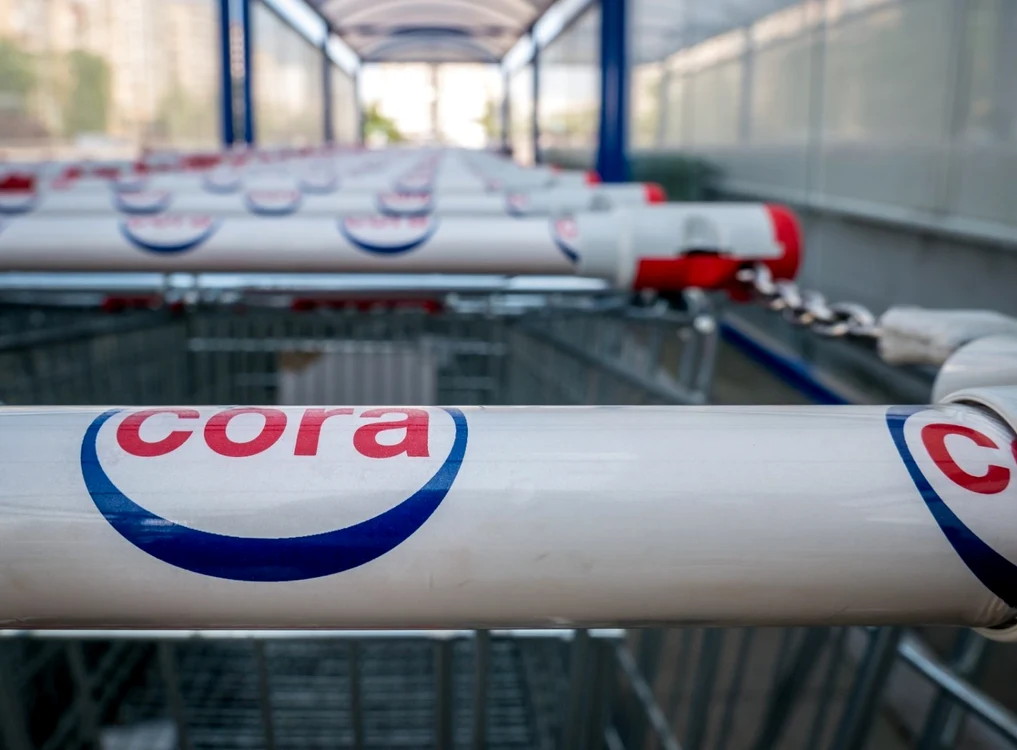 Cărucioare de cumpărături pe mânerul cărora scrie Cora