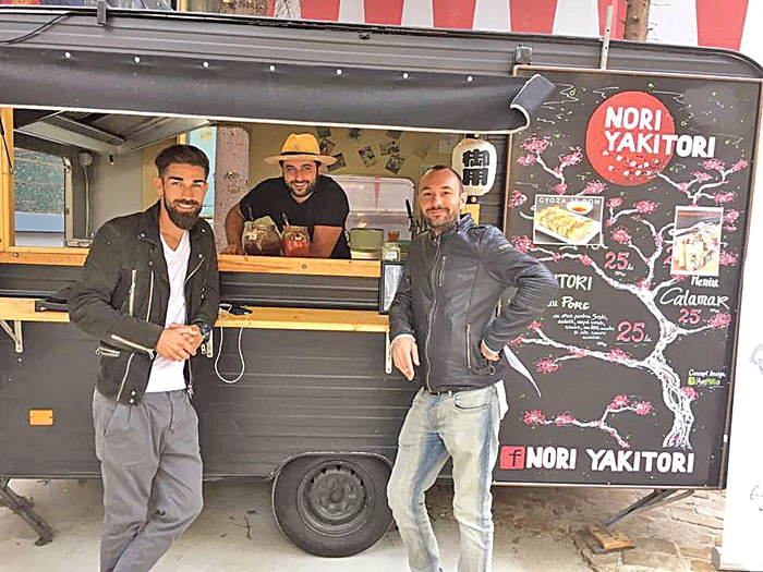 Robert Petrescu  (mijloc) vinde mâncare  japoneză într-o rulotă