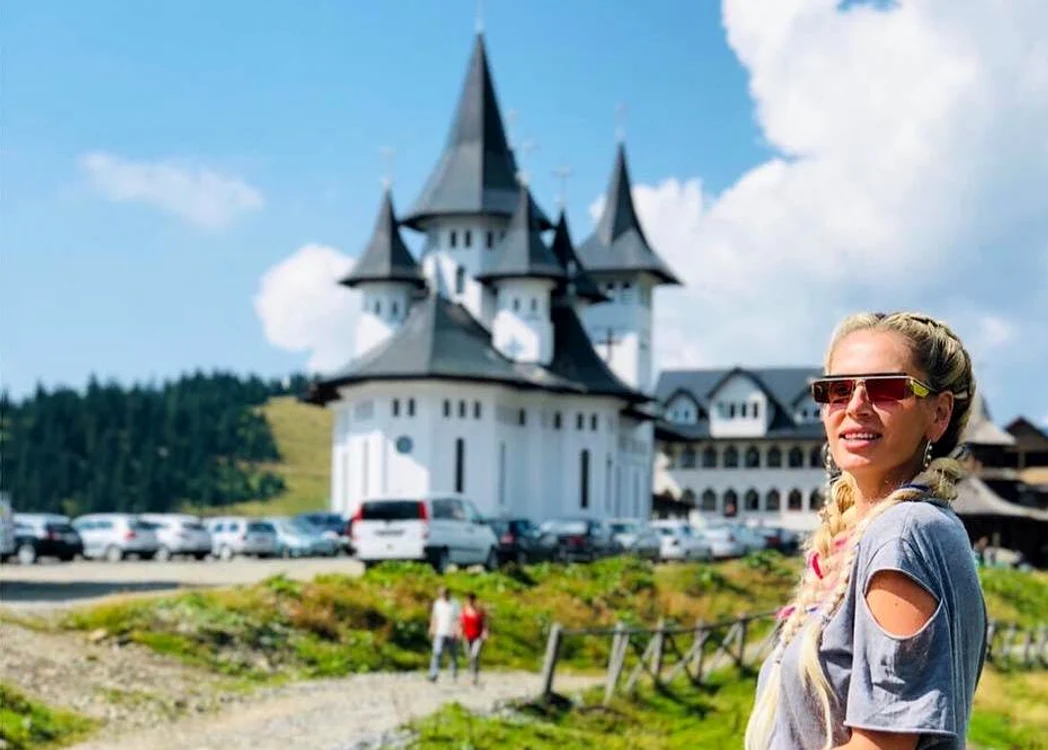 
    Andreea Bănică s-a fotografiat în pantaloni scurți, cu Mănăstirea Prislop în fundalfoto: arhivă personală/Instagram  