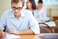 student with glasses writing jpg