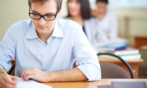 student with glasses writing jpg
