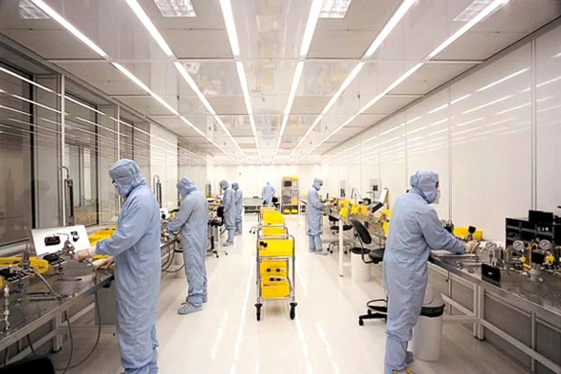 Fabrică de semiconductori în care angajații sunt îmbrăcați în combinezoane albe