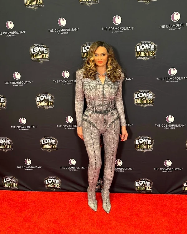 Tina Knowles, într-o salopetă mulată gri, pe covorul roșu