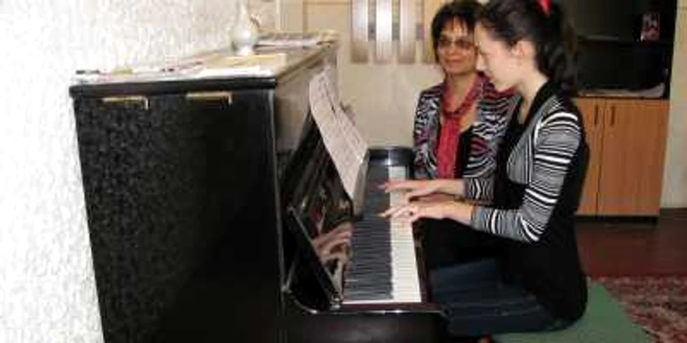 Profesoara Mady Crângaşu le arată elevilor tainele pianului