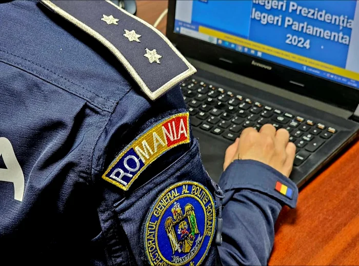 Polițist în uniformă se uită la un laptop