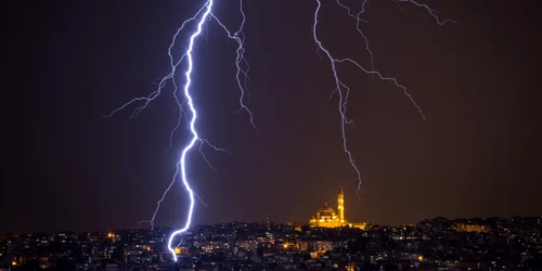 Fulgere brazdează cerul Istanbulului pe fundal se vede luminată Moscheea Fatih în Istanbul Turcia FOTO Guliver / Getty Images / Chris McGrath