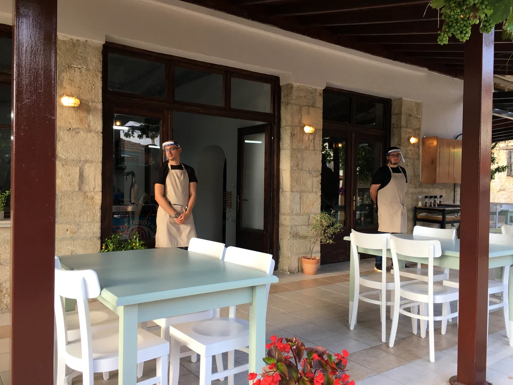 Chelnerii din Halkidiki își așteaptă oaspeții cu mesele distanțate și cu viziere pe față