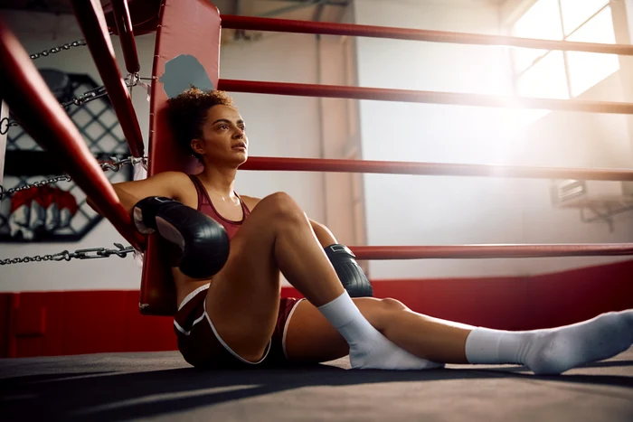 Femeie boxer odihnindu-se în ring - Shutterstock