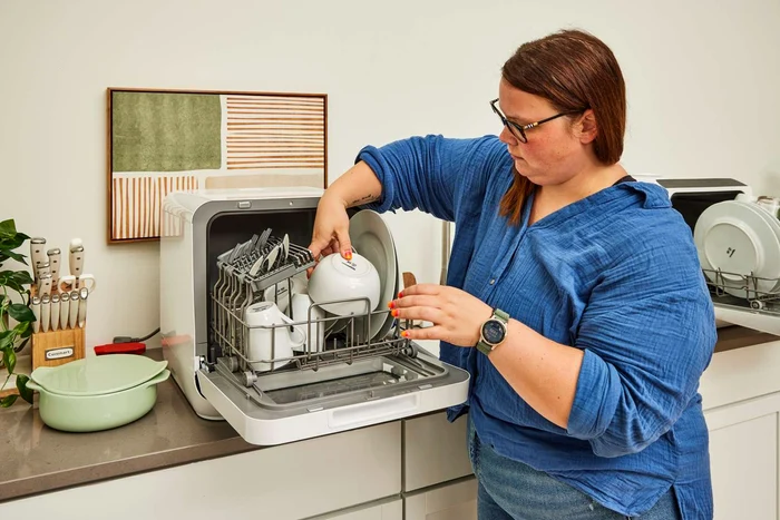 Femeie care aranjează vesela într-o mașină de spălat vase compactă Sursă The Spruce jpg