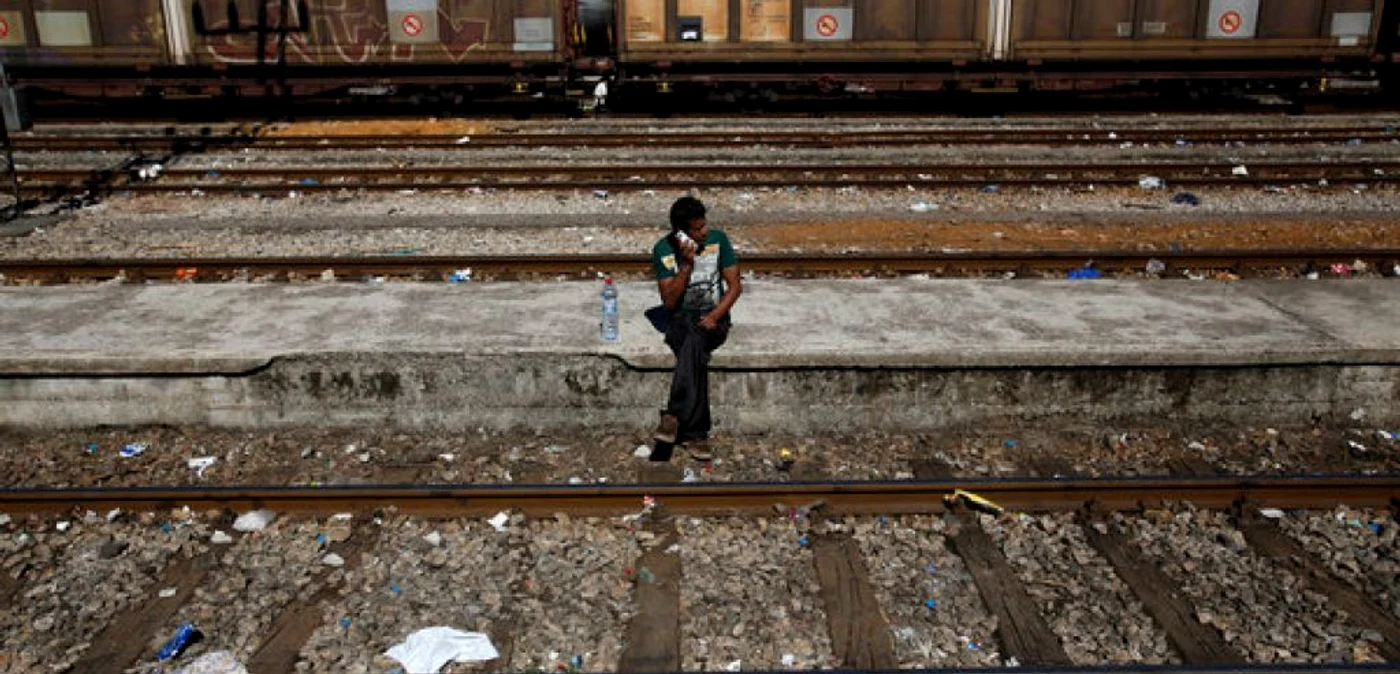 Un imigrant vobeşte la telefon în timp ce aşteaptă un tren care să-l ducă din sudul Macedoniei în Serbia FOTO AP