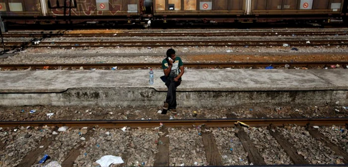 Un imigrant vobeşte la telefon în timp ce aşteaptă un tren care să-l ducă din sudul Macedoniei în Serbia FOTO AP