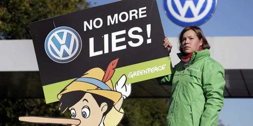 Un activist al organizaţiei de protecţiei a mediului Greenpeace protestează în faţa fabricii Volkswagen din Wolfsburg. FOTO AP