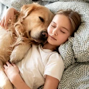 Copil care doarme cu un câine în pat FOTO Shutterstock