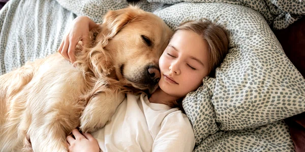 Copil care doarme cu un câine în pat FOTO Shutterstock
