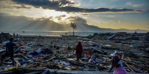 Indonezienii stau printre resturile din satul Mamboro din Palu devastat de cutremur în centrul Sulawesi Indonezia Potrivit unui raport al BNR cel puţin 1 571 de persoane au murit ca urmare a unei serii de cutremure puternice care au lovit centrul Sul