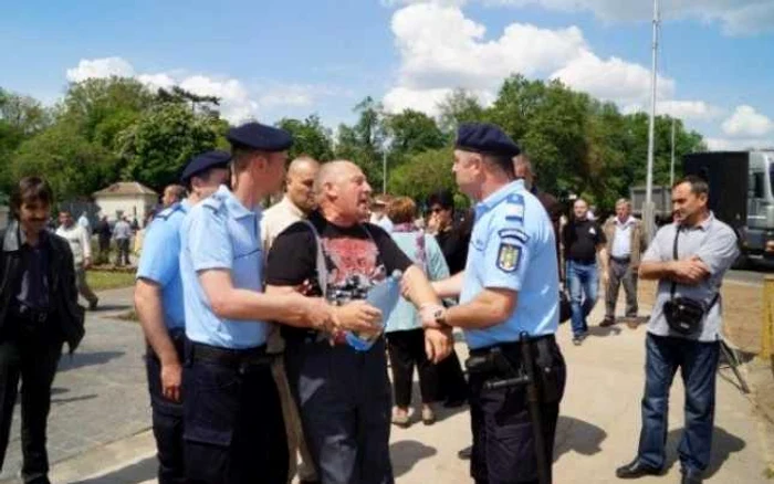 Unul dintre protestatari a fost luat pe sus de jandarmi. FOTO -buletundecarei.ro