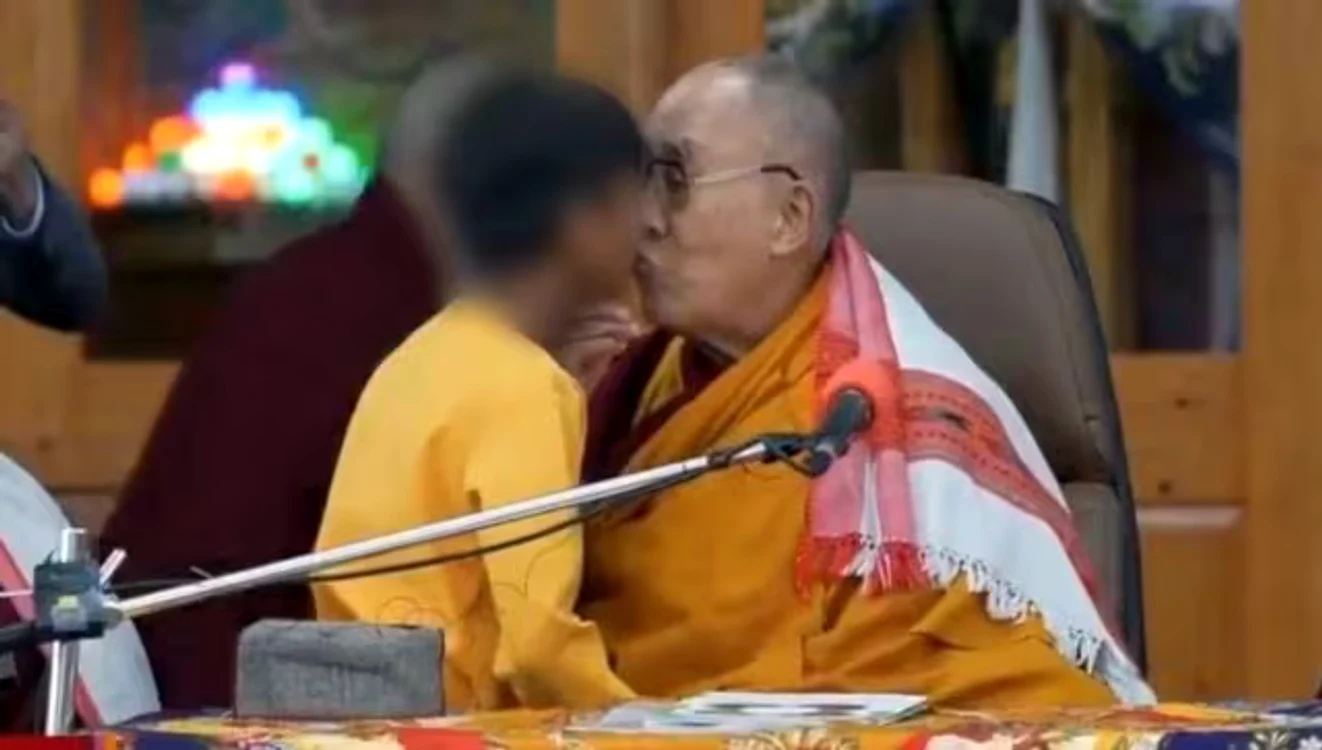 Dalai Lama sărută pe gură un copil. Foto: Twitter.