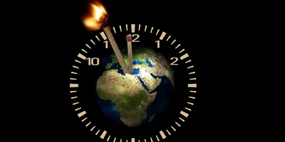 Globul pământesc în centrul unui ceas cu chibrituri drept pendule, unul dintre el fiind aprins   pixabay jpg