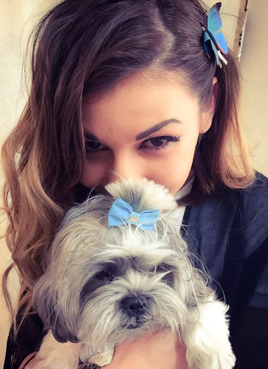 Alina Eremia și-a pus fundiță bleu în păr, la fel cum i-a pus și cățelușului din imagine