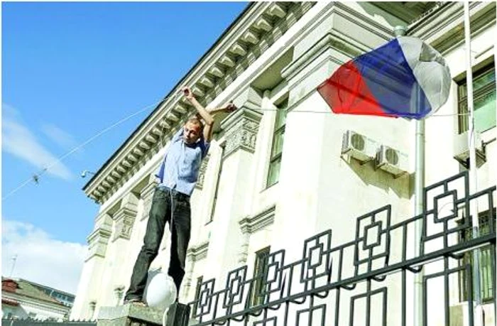 Un protestatar dă jos steagul Rusiei