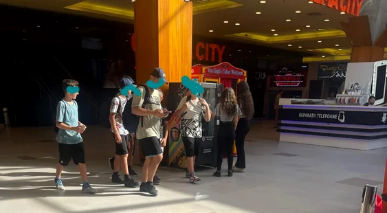 Copii care stau la coadă la automatul de VAP-uri dintr-un mall FOTO: Oana Șlemco