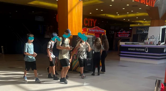 Copii care stau la coadă la automatul de VAP-uri dintr-un mall FOTO: Oana Șlemco