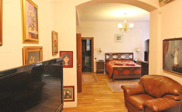 Așa arată dormitorul: un pat de mijoc și multe tablouri pe pereți