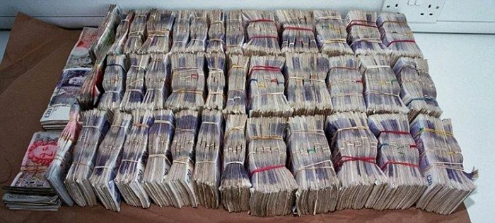 Zeci de teancuri cu lire sterline așezate pe o masă