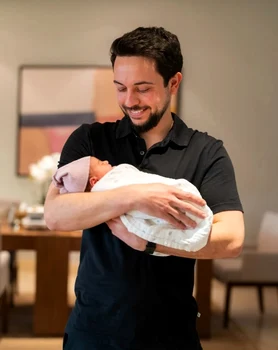 Prințul Hussein al Iordaniei cu Prințesa Amina în brațe 