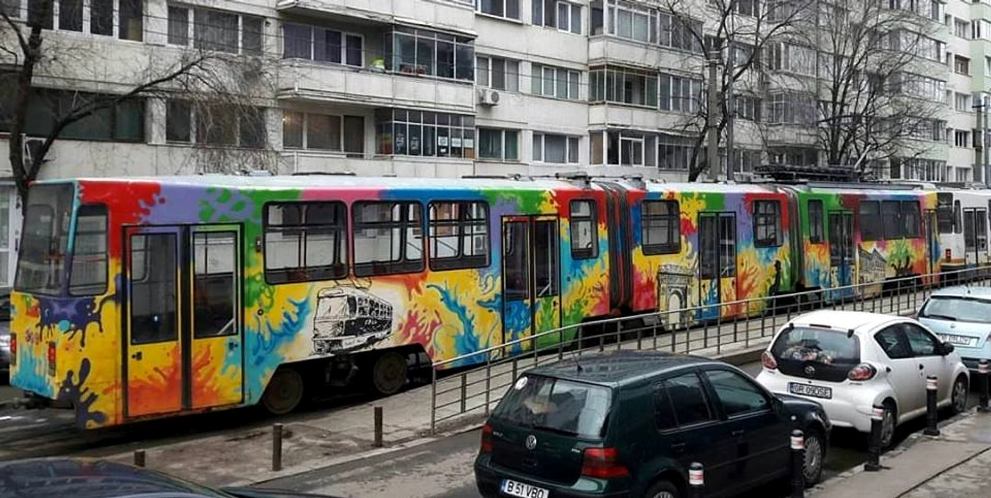 Tramvaiul pictat este o pată de culoare printre nuanțele de gri ale orașului
