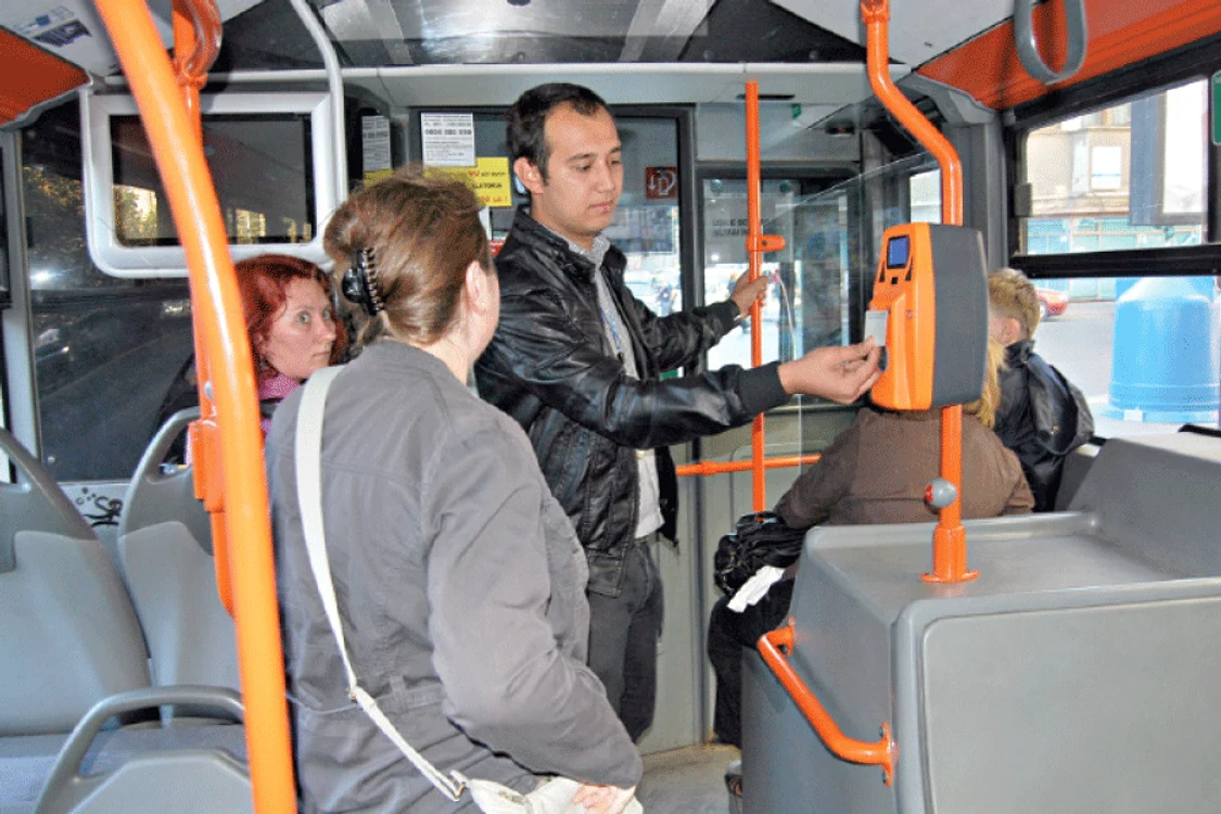 
    Nicolae Lazăr, 22 de ani,  controlor, îi arată unui călător  cum trebuie să valideze cardul  