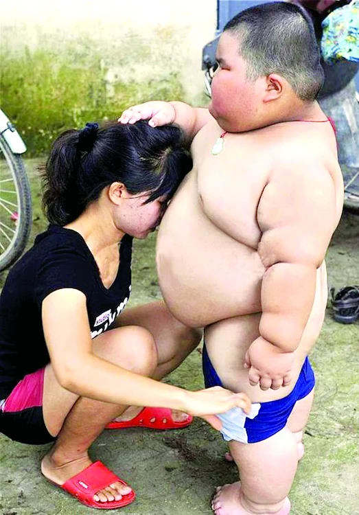 Băiatul e aşa de gras, că are nevoie să fie îmbrăcat de mama sa