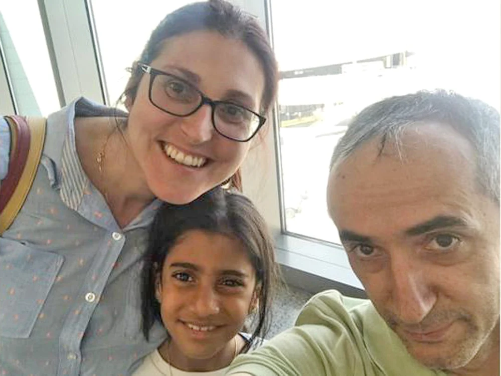 
    Între aceste două fotografii  a trecut o lună. Pe 21 iulie,  familia Săcărin era pe  aeroport, gata de îmbarcare.  Pe 21 iunie, Sorina era  bruscată la Baia de Aramă  