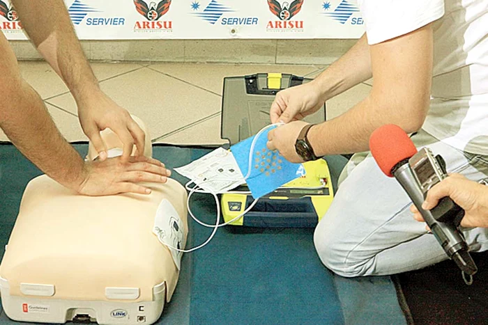 Pasul 2 Lipiţi electrozii  pe pieptul  bolnavului. Se  face respiraţie  gură la gură şi  masaj cardiac