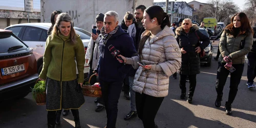 Călin Georgescu, însoțit de soția Cristela Georgescu, personal de pază și reprezentanți ai unui post de televiziune, face cumpărături în Piața 16 Februarie, în București. FOTO Inquam Photos / Octav Ganea
